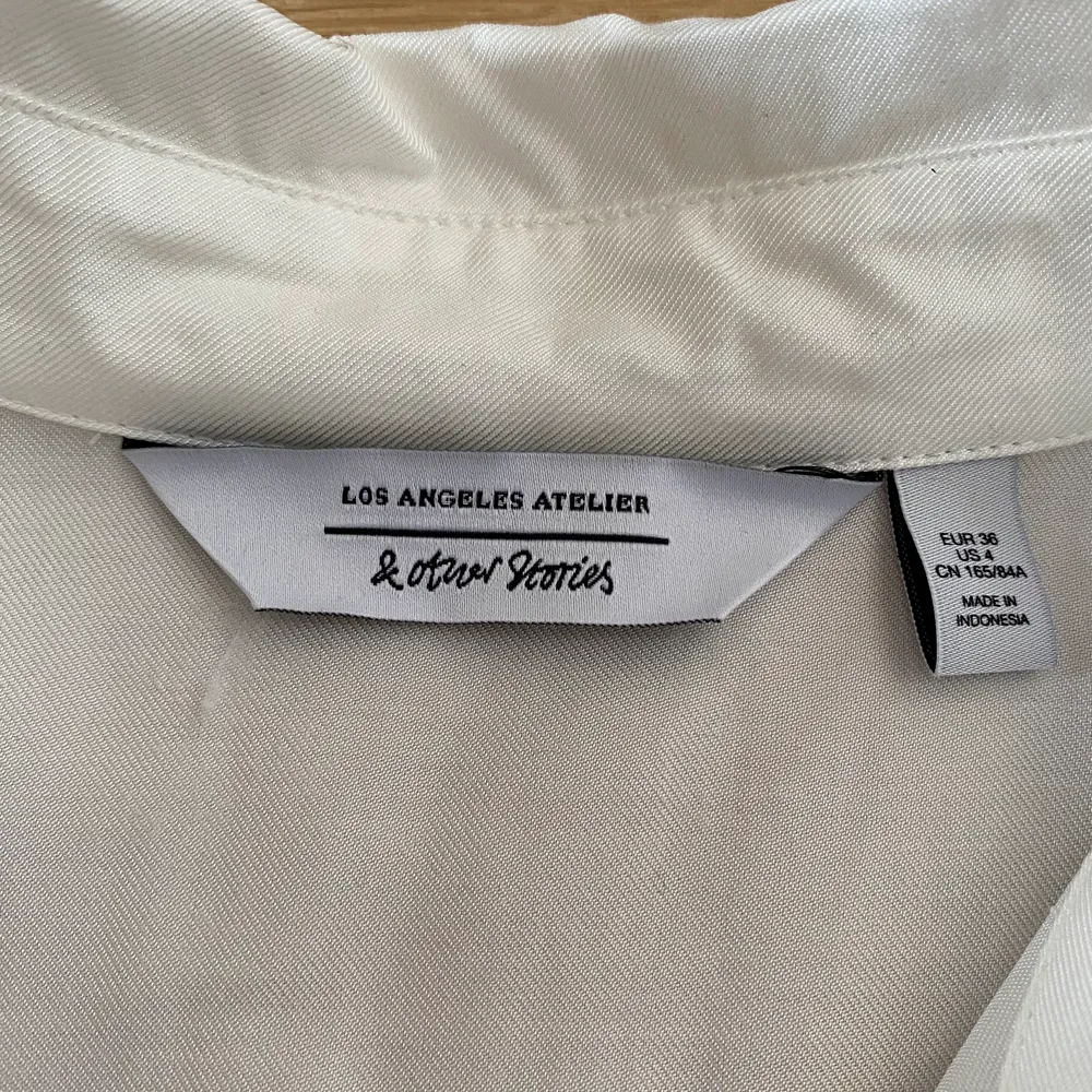 En jättefin vit lite kortare blus/skjorta med en liten knytning där fram och i nyskick (aldrig använd). Blusar.