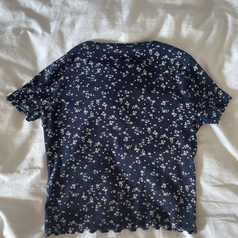 Jättefin mörkblå ribbad topp från Hollister i storlek xs. Skulle säga att den mer är storlek S och är väldigt stretchig så skulle därför passa S/M hur bra som helst. Den har detaljer av vita blommor. Säljer eftersom den tyvärr aldirg kommer till användning. Nypris ca. 200kr på Hollisters hemsida.. Toppar.