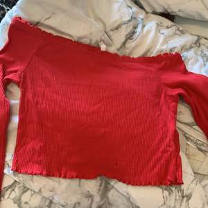 En röd tröja som är lite kort vid magen och axlarna syns den är från h&m och säljer för passar inte mig