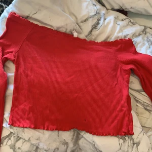 En röd tröja - En röd tröja som är lite kort vid magen och axlarna syns den är från h&m och säljer för passar inte mig