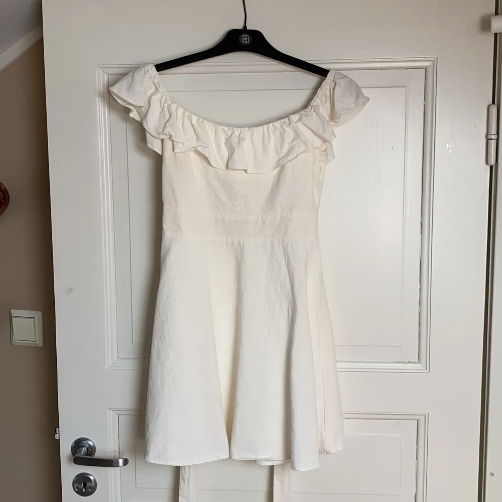 Säljer denna jättefina vita klänning som är köpt på Zara då den inte passar mig längre.  Klänningen är väldigt sparsamt använd max 5 gånger, men den har tyvärr fått ett litet hål på ryggen vid dragkedjan men det syns inte så tydligt (se bild 3). . Klänningar.