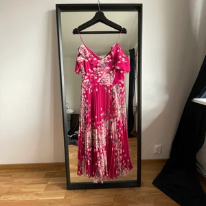 Blommig finklänning - Blommig finklänning inköpt till min kandidatexamenssittning. Använt två gånger. Nu för liten för mig men sitter så fint på! Dragkedja.