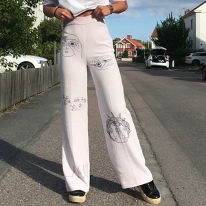 Byxor med tryck  - Ett par helt unika och såå coola raka/utsvängda byxor med egenritade tryck!! Färgen är lätt ljusrosa men nästintill vita och alla tryck är ritade med textilpenna så de går att tvätta🍓🍓 passar xs-s och de går hela vägen till marken på mig som är 169cm lång som referens💗   Tveka inte att skriva om du har fler frågor eller vill ha bättre bilder på alla tryck!  Kika även gärna in på min sida där jag säljer mer egensydda och virkade kläder av återvunnet material🌳🌳 Finns även på instagram @lucu.studio