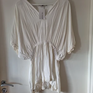 Strand klänning  - Supersöt strand/after beach klänning, vit med spets på armarna och nertill. Oanvänd! Är som en Medium i storlek.