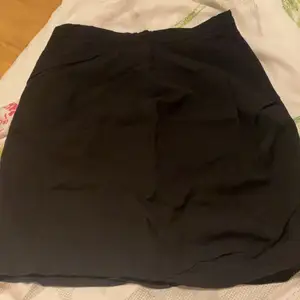En superfin svart kjol där materialet är som kostymbyxor 