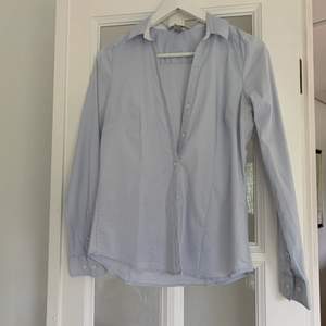 En blå enkel skjorta som alltid är bra att ha i garderoben. Denna är för liten så hann inte använda den, därav i bra skick och fräsch. 