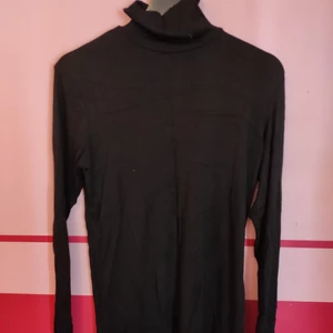 Svart polo - Svart ribbad polotröja, långärmad. Fint skick.
