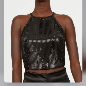 H&M svart paljett topp - Säljer en slutsåld svart paljett topp från H&M. Toppen är helt oanvänd och har prislappen kvar.