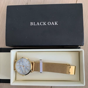 armklocka - För tillfälligt borta! marmor och guld klocka från black oak, går att justera, bandet är 22cm lång, inga tydliga defekter. pris diskuteras tillsammans (+frakt)