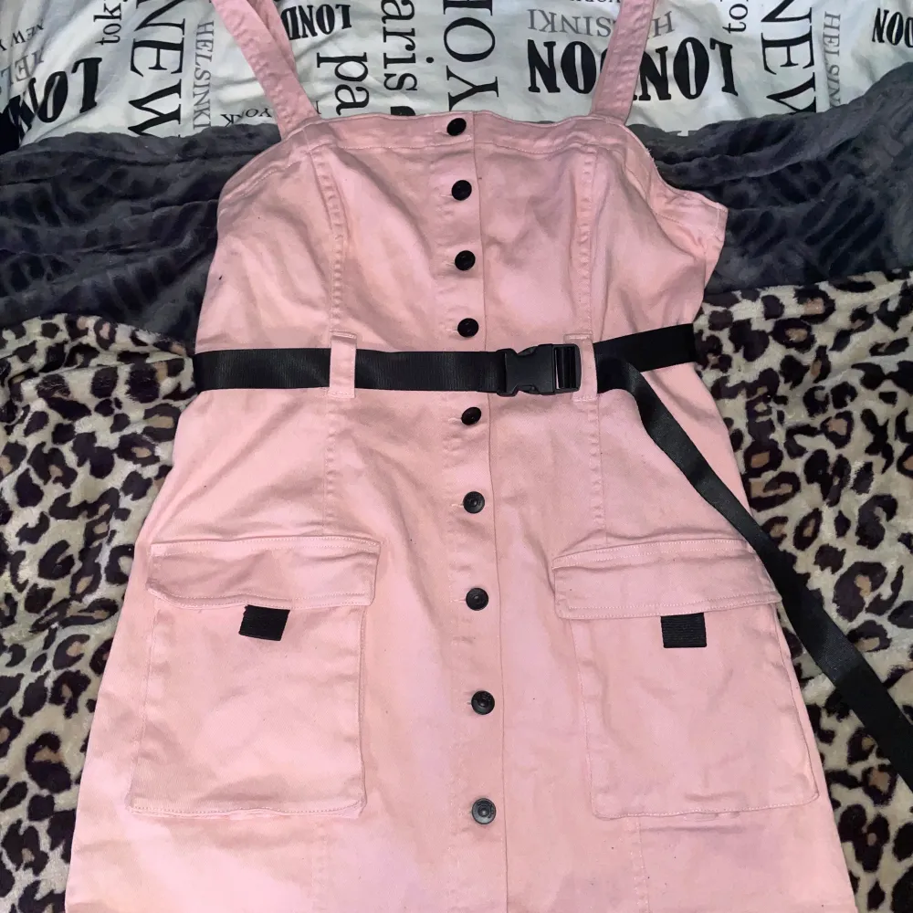 Jätte fin klänning från H&M i jeans tyg i ljus rosa färg med svart bälte. Köpt för närmare 2 år sedan endast använd 2 gånger i Max 2 timmar. Så nästintill oanvänd. Storlek 44. Den är lite stretchig. Sitter snyggt tjat och även lite löst.. Klänningar.