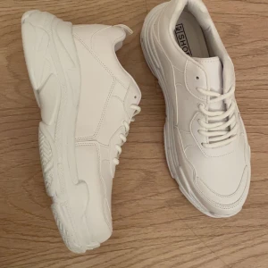Vita chunky sneakers nelly  - Helt nya vita sneakers från Nelly, aldrig använda då de va för stora. Storlek 39 (har vanligtvis 38/39). Köpta för 399kr. De ingår även andra snören som är randiga!! Köparen står för frakt & halva priset betalas innan skorna fraktas iväg 🤍 kan mötas i Halmstad!! Om flera är intresserade blir de budgivning.