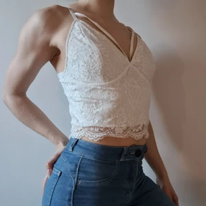 Vitt spelsinne med band över brösten - Snyggt, vit, spelsinne med sensuella band över brösten. Stl: L  (jag bär vanligtvis stl: S och fyller tyvärr inte ut bysten). Sensuellt linne på rätt person. Justerbara axelband. 