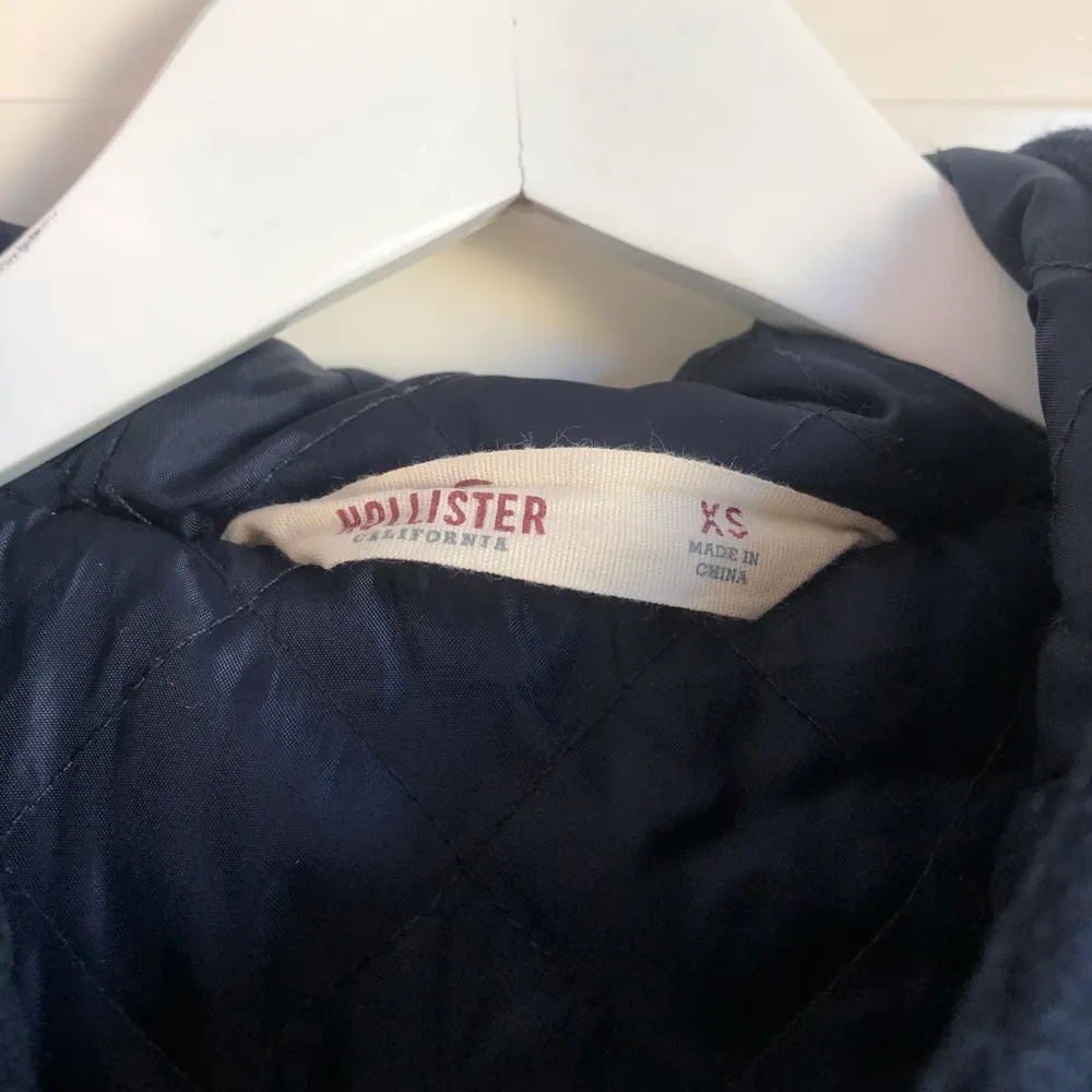 Marinblå kappa från Hollister i stlrk XS. Max använd 3 gånger därav precis som ny! Jättefint skick. Väldigt skön pga luva och tjockare. . Jackor.