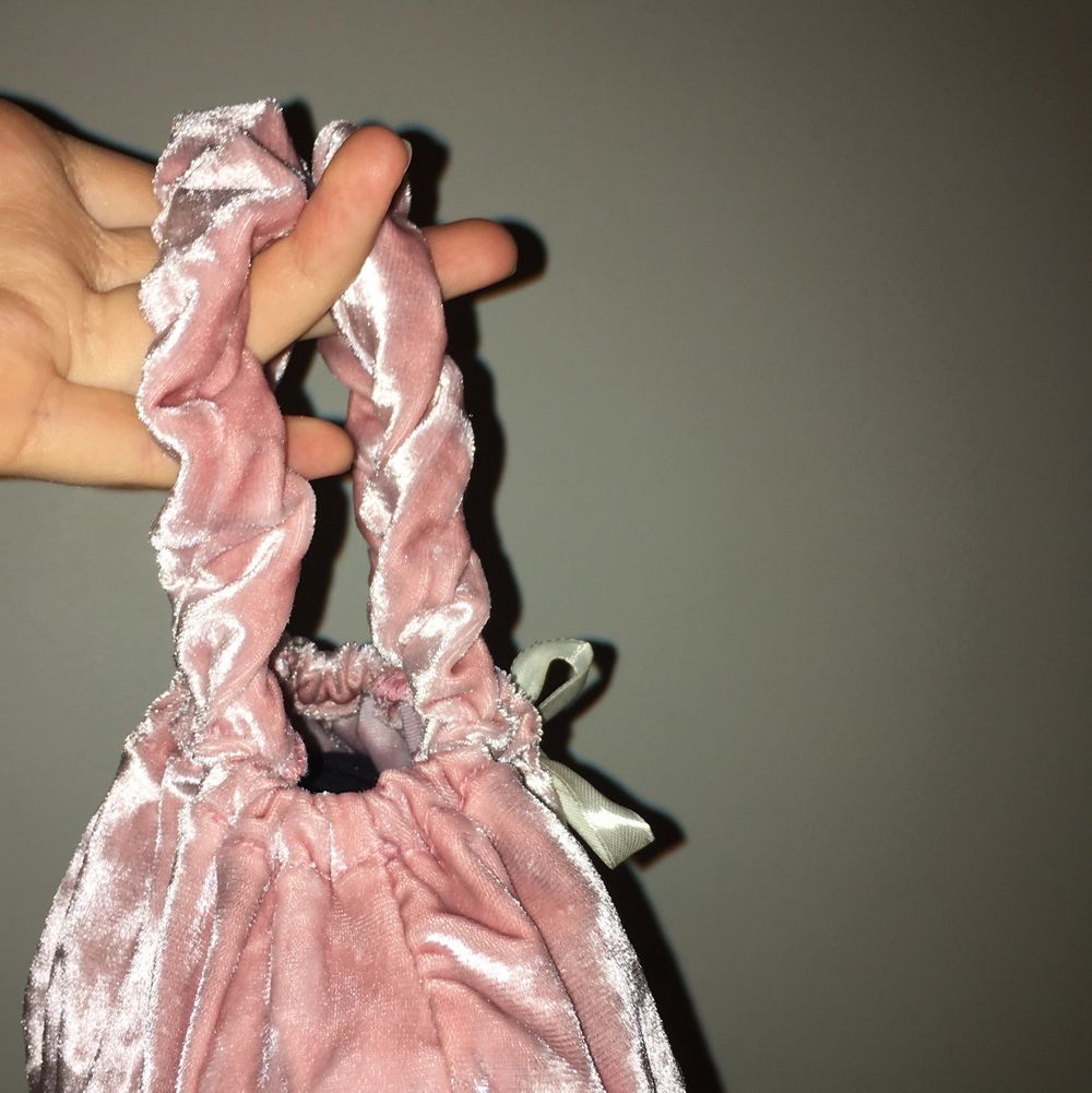 Supersöt liten handväska i återanvänt velourtyg. Väskan är hemmasydd. Handtagen är lite elastiska såsom scrunchies och väskan försluts med ett satinband med hjärtan av glas. Väskan är rymlig och anpassar formen efter innehållet. Önskas mer information ov väskan är du välkommen att kontakta mig. . Väskor.