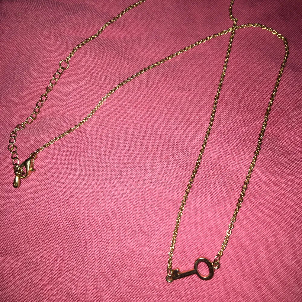 Guldigt halsband med nyckel-”berlock”💞🗝 (guldfärgen syns dock inte riktigt på bilden) Kedjan är 48 cm lång men går att justera om man vill ha den kortare😊 frakten ingår i priset. Accessoarer.