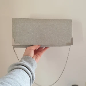 Kuvertväska  - Silvrig kuvertväska med glitter. Kedjan är silverfärgad.