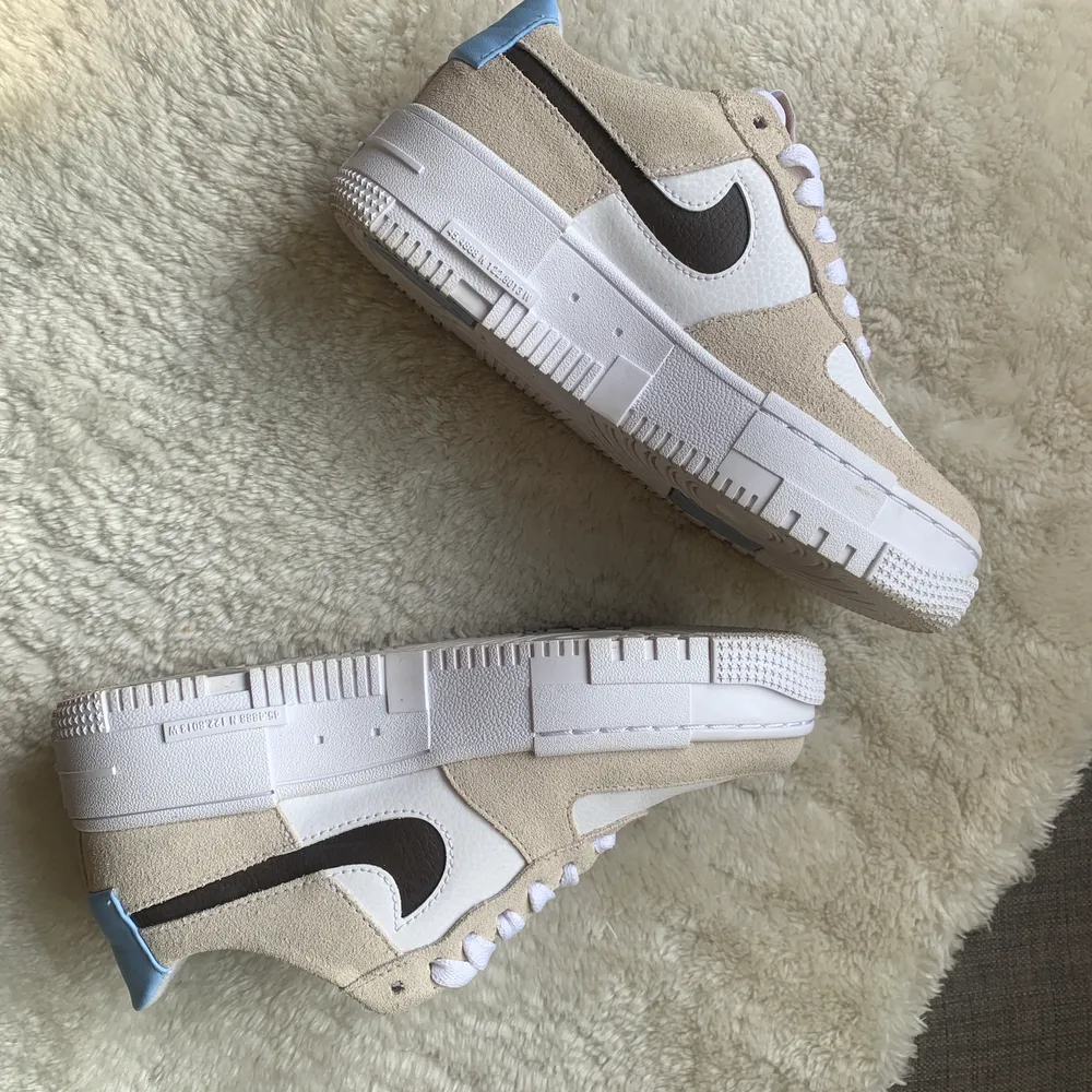 Beige/vita Nike Air Force Pixel med ljusblå detalj på hälen. Så otroligt fina men tyvärr för små. . Skor.