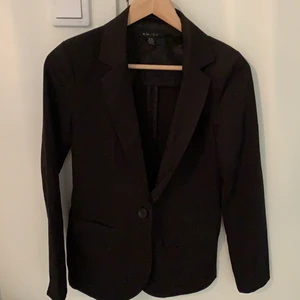 En svart blazer - Jag säljer en svart figursydd blazer med små axelvaddar i storlek 36. Passar även en 34. Den har en knapp och två fickor. Jag själv märker inte av så mycket att den är figursydd men jag säljer den för att den är för liten för mig. Den är i ett fint skick och den använd några gånger. Frakt ingår vid leverans. 