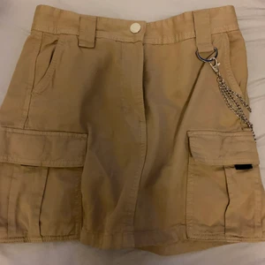 kjol med kedja - beige kjol med kedjor och andra detaljer