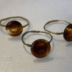 Guldiga ringar med bruna knappar - Ringar i tunn guldig ståltråd med bruna knappar!🤎✨(bara två finns kvar!)