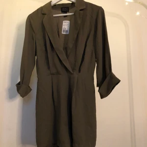 Klänning  - En militär grön klänning ifrån forever 21 i stl m den är aldrig andvänd och lappen sitter fortfarande kvar den har ett skärp i midjan som man kan spänna åt.