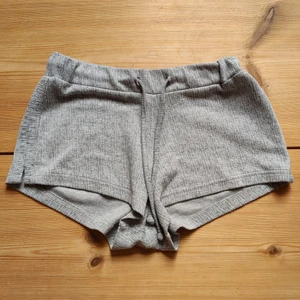 Korta mjukissjorts Strl XS - Korta gråa mjukisar som sitter högt. I bra kvalité förutom att det är knopprigt men jag skulle inte säga att man stör sig på det. Jag har haft dem länge men har inte använt dem mycket! Jag säljer dem för att dem är för små.
