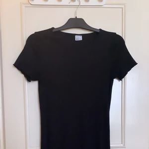 Klänning  - En söt svart tight super stretchig klänning i ribbat mönster med fint vågit slut på armar & ben i storlek M. Stämmer överens men normal storlek (i fint skick)