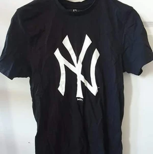 Svart T-shirt  - Svart t-shirt med vitt märke storlek M