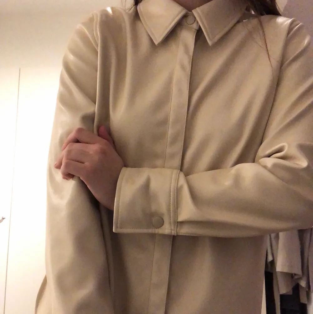 En beige faux skinn skjorta från Gina Tricot i storlek 36! Knappt använd så som nyckick! . Skjortor.