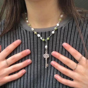 Nyckel halsband  - Handgjort halsband (av mig) med en nyckel berlock 🗝🤍 Halsbandet har en förlängningskedja som gör halsbandet justerbart. Det är gjort av äkta sötvattenspärlor, gröna jade ädelstenar, silverfärgade stål hjärtan och samt silver pläterad stål. Kontakta mig om du är intresserad🥰