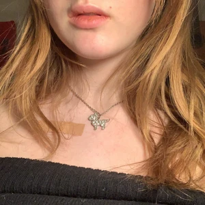 Halsband - Silvrigt halsband med vita stenar med en hund. :)