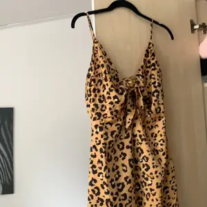 Klänning i sidenmaterial, leopard mönster med knyt fram. Längre modell! Aldrig använd 