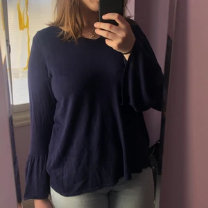 Blå tröja med volanger - En skön blå tröja. V-ringad med volanger och rak i modellen. 