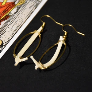 Örhängen ben  - Örhängen i guldig metall med ben och nickelfria krokar. 