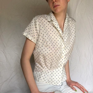 Vintage figursydd prickig blus - Säljer denna jättefina vita vintageblus från 50/60-talet med blå prickar, så fin och klassisk perfekt till sommaren med jeans eller en kjol för en Audry Hepburn vibe. En knapp saknas (se bild), annars mycket bra skick🌷🌷🌷