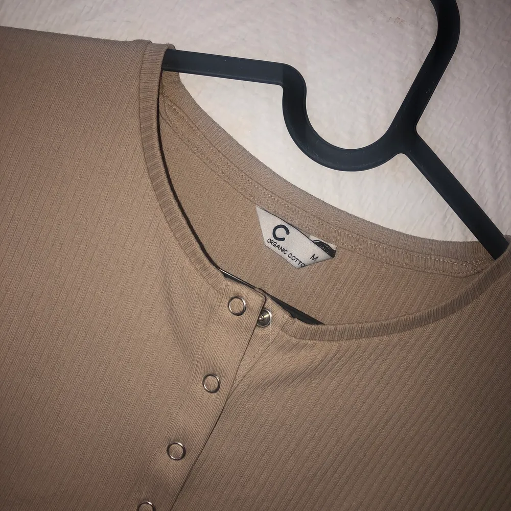 En beige t-shirt från cubus andvänd 1 gång men knappar som går att öppna vid bröstet.💓. T-shirts.