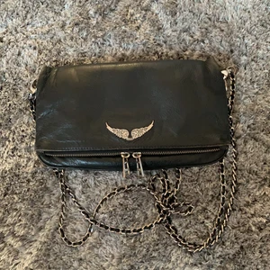 Svart Zadig&Voltaire Väska - Jag säljer nu min svarta Zadig väska då den inte kommer till användning längre. Den är köpt på den officiella zadig&voltaire i Stockholm. Det medföljer två kedjor och påse. Den är köpt för runt 3200. 