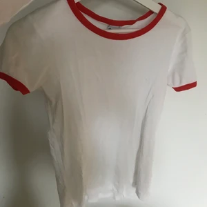 Snygg vit tshirt med röda detaljer - En nice vit tshirt med röda detaljer som har den perfekta längden, inte för lång och inte för kort. Storlek small.