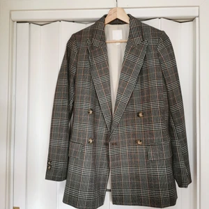 Rutig rak kavaj hm - En rutig kavaj i rak modell med snygga detaljer. 