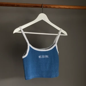 Blått linne med text - Jag säljer ett blått linne i ribbad bomull. Plagget är bekvämt och påminner om ett somrigt 90-tals linne :)