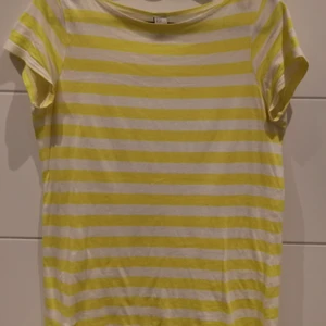 Randig t-shirt i vit och gul  - Randig t-shirt i vit och gul från Zara i storlek 164 cm. 💛 Frakt tillkommer 