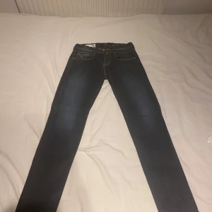Mörkblå Replay Anbass jeans - Säljer ett par mörkblå Replay Anbass jeans med klassisk femficksdesign och snygga kontrastsömmar. Jeansen har skinny passform och är tillverkade i stretchigt denim för extra komfort. Perfekta för dig som gillar stilrena och tidlösa jeans. Buda gärna! FÖRST TILL KVARN!