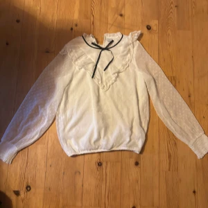 blus - gullig blus från lindex, vit med detaljer och en svart rosett på framsidan, barn storlek men passar mig som s-m bra