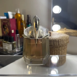 Alien Goddess Eau de Parfum från Mugler - Alien Goddess från Mugler är en parfym för kvinnor Doften har tydliga inslag av vanilj, pudriga toner, vita blommor, trä, citrus, mysk och blommiga noter. Perfekt nu till sommaren! Ca 25ml kvar av 30ml 
