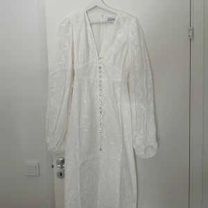 Adoore klänning  - Säljer mina fina vita Adoore klänning i storlek 36. Köptes för 1700kr o säljer för 1200kr. På sista bilden ser man att den är lite sliten på sista knappen men ingen annan defekt på hela klänningen. 
