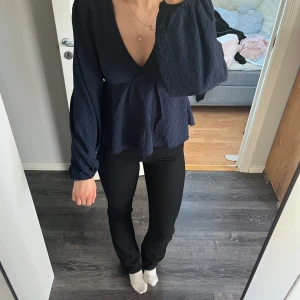 Mörkblå blus med v-ringning från Nelly - Säljer en mörkblå blus från Nelly med djup v-ringning och långa, vida ärmar. Blusen är helt ny, endast använd 1 gång 🥰