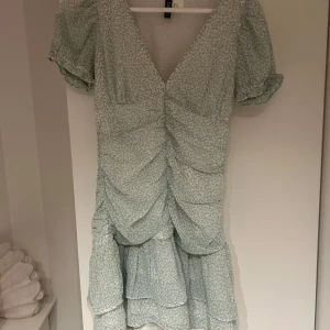 Ljusblå blommig kortklänning från H&M - Supersöt l kortklänning från H&M som är perfekt till sommaren, skriv för frågor 