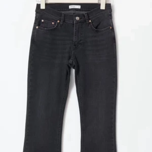 Svarta bootcut jeans - Snygga svarta jeans med bootcut passform och klassisk femficksdesign. Jeansen har hög midja och subtila sömmar, perfekta för en stilren look. 