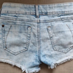 Ljusblå jeansshorts Tally Weijl - Säljer ett par ljusblå jeansshorts från Tally Weijl med slitna kanter. Shortsen har låg midja. 