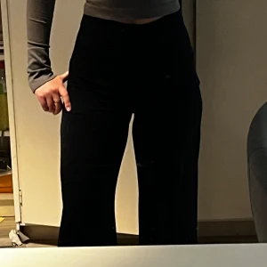 Svarta vida byxor från BikBok - Säljer ett par svarta byxor från BikBok med hög midja och vida ben. Byxorna har en stilren look och passar perfekt till många olika outfits. Materialet känns mjukt och stretchigt för extra komfort.